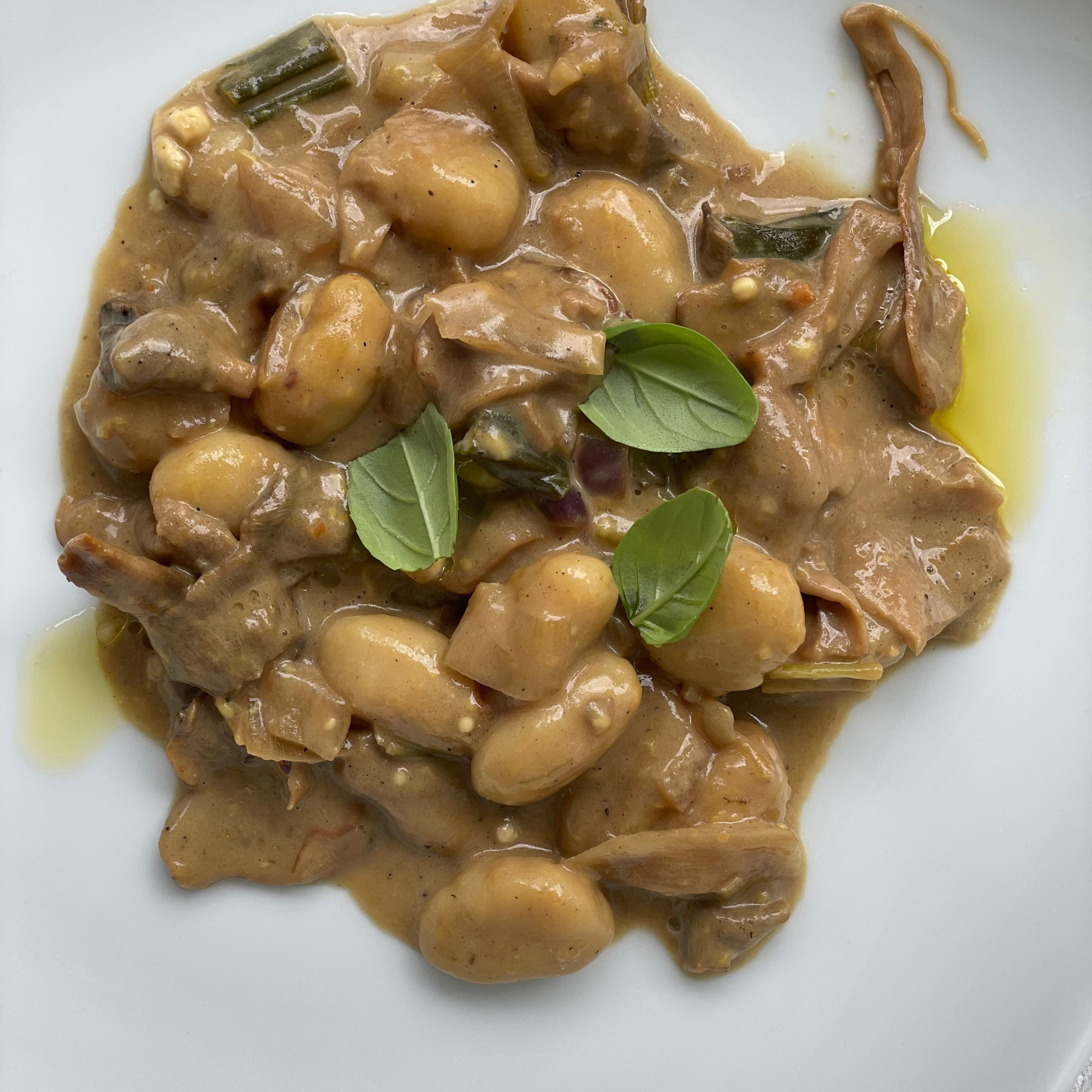 Organic Dried Porcini pasta with mushroom sauce and basil on the plate.