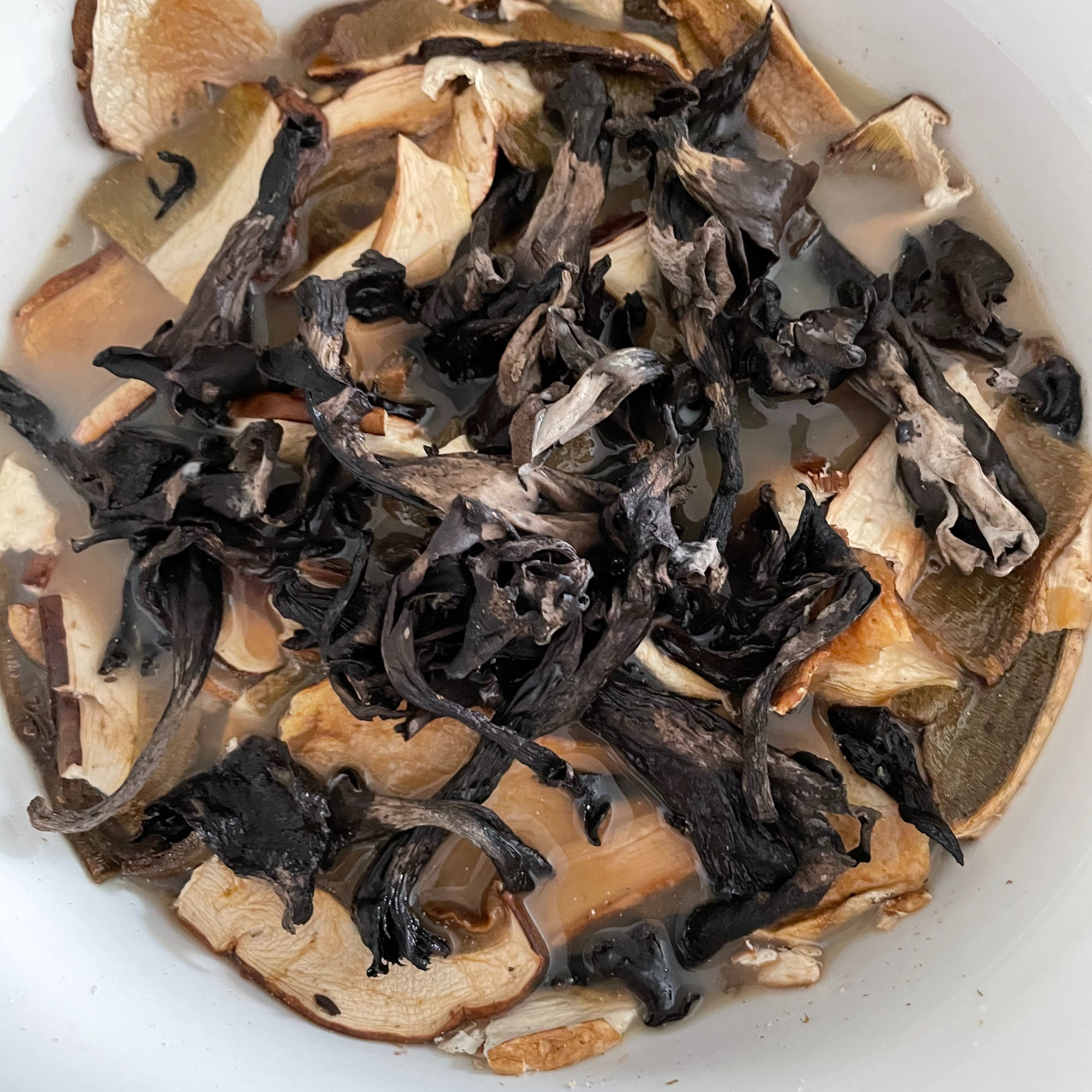 Wild mushrooms, in this case dried Black Trumpet and Porcini covered with water in a big bowl. 